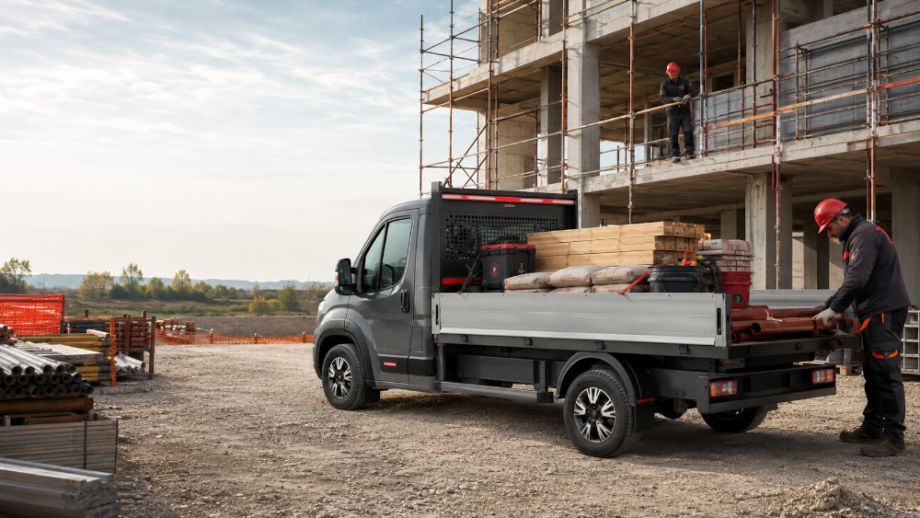 Furgone con cassone aperto carico in cantiere edile.